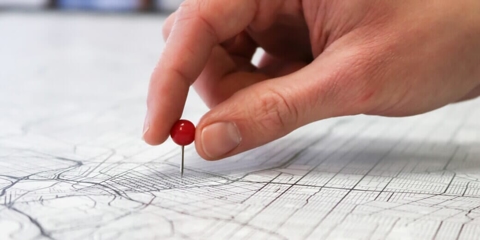 Hands putting pins in map - Multiple Franchise Locations